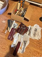 Overview of lot showing box of knives/utensils, cleavers and flatware sets
