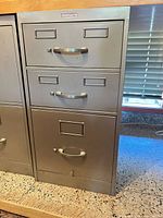 Front view showing three drawers with pulls and label holders