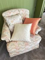All three pillows stacked on armchair showing colors and fabrics