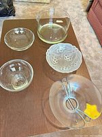 Five glass bowls of various shapes and finishes displayed on table