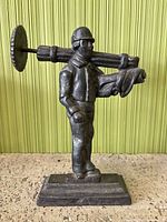 Front view of cast iron worker figurine on pedestal base