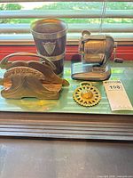 All four items grouped: brass holder, wood-brass cup, Boston Champion sharpener, brass gear
