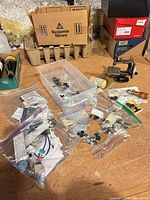Lot overview with bags of buttons, storage bin, Singer mini sewing machine visible