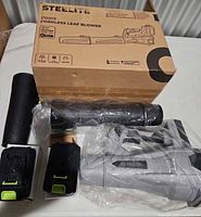 Box and all components laid out: blower body, tube, two batteries, charger