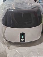 Front view of ball launcher unit in protective bag, showing control panel