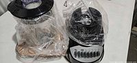 Blender base wrapped in plastic alongside jar and lid in protective wrap