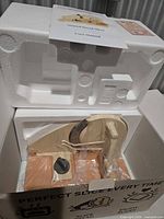 Box interior showing packed bread slicer and manual