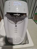 Front view of Comfyer formula maker showing display, controls and spout