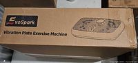 Sealed EvoSpark vibration plate exercise machine box top view showing brand graphic