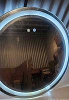front view of mirror powered on, LED ring illuminated, touch icons visible