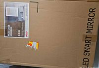 Sealed shipping box with branding, model MC01 20x28, LED SMART MIRROR text visible