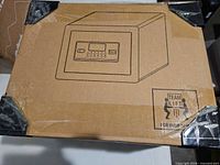 Sealed carton with safe illustration, corner protectors visible
