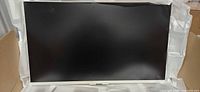 Front view of monitor powered off in packaging