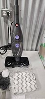 Full view of steam mop with accessories on table