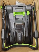 Folded Steelite lawn mower inside box