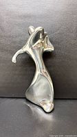 Front view of polished aluminum golfer sculpture