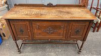Full front view of oak sideboard buffet showing overall design, doors, drawer, legs