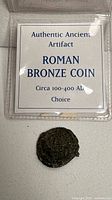 Plastic holder with label and coin beneath