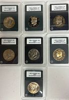 Group shot of six encapsulated Kennedy Half Dollars