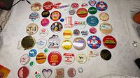 Overall group of ~41 assorted buttons laid out on white cloth