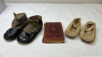 Two pairs children’s shoes and prayer book laid out