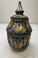 Full view of lidded jar front showing enamel panels and silver trim
