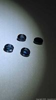 Four oval blue sapphires on neutral background