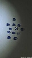 Group of 11 square blue sapphires on dark background