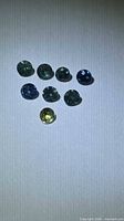 Eight round sapphires arranged on neutral background