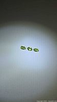Three oval green peridot gemstones aligned