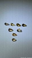 Eight pear cut champagne orange gems on neutral background