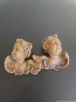 Front view of both cherub wall plaques showing design details