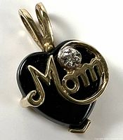 Front view of pendant highlighting onyx heart, gold "Mom" script and clear accent