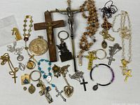 Full lot overview showing crosses, rosaries, medals, bracelets and keychains