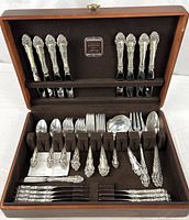 Opened wooden chest showing full set of flatware, top and bottom trays