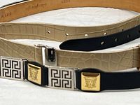 Black belt showing Medusa and Greek key plaques with cream croc belt underneath