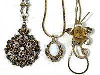 Three necklaces laid side by side showing overall design and length