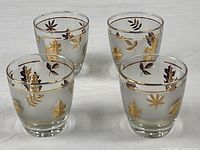 Four frosted glasses showing leaf pattern and rims