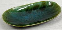 Top view of oval ceramic bowl showing green-blue drip glaze