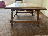 front view of solid knotty pine square coffee table showing legs and stretcher