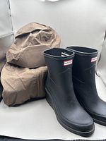 Boots front view with folded brown jacket beside