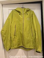 Front view of lime green Arc'teryx Beta LT jacket on hanger