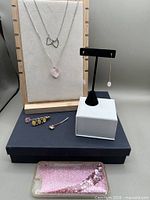 Group shot showing both necklaces on display, threader earring, hair clip, bobby pin and phone case