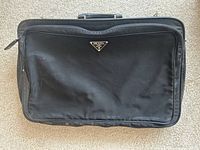 Front view of Prada black nylon briefcase showing triangle logo