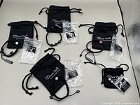 Five Tresor Paris pouches with bracelets and labeled plastic sleeves
