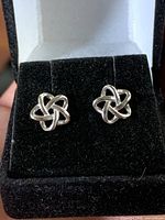 Front view of both sterling silver Celtic knot stud earrings on black display pad