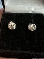 Front view of both sterling silver love knot studs in display box