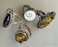 Group of four sterling silver rings showing stones and designs