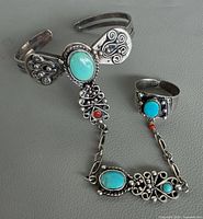 Full view of cuff, chain and ring showing stones and design