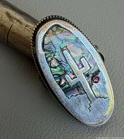 Front view showing abalone inlay, cactus cut-out and red cabochon